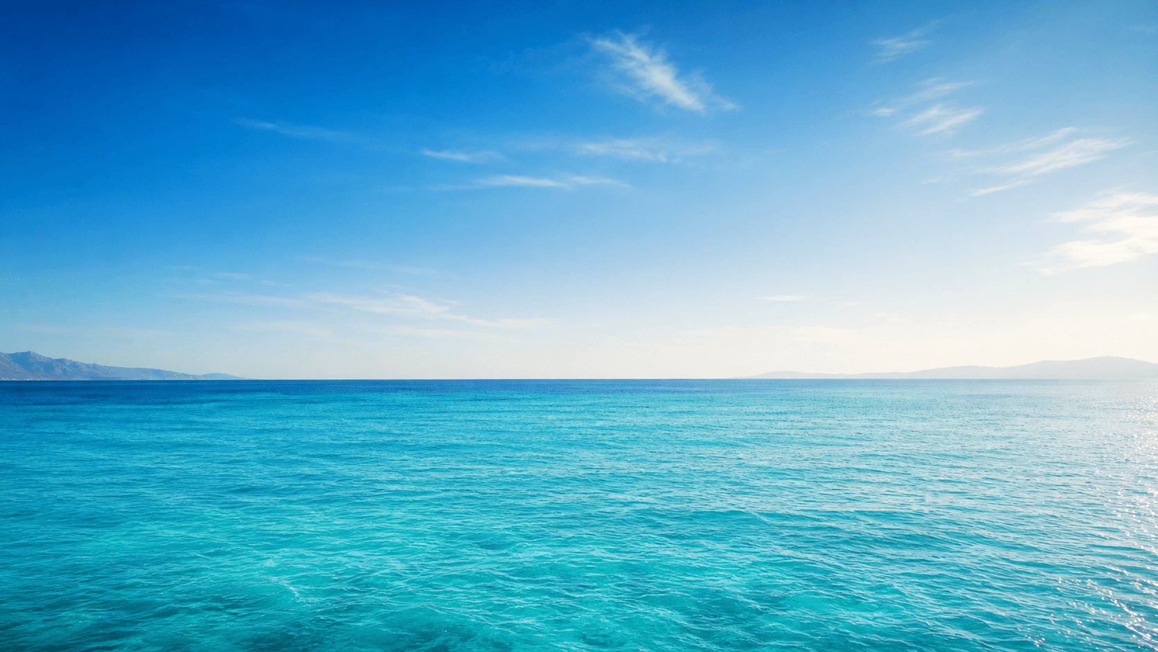 A bright blue sea beneath a summer sky