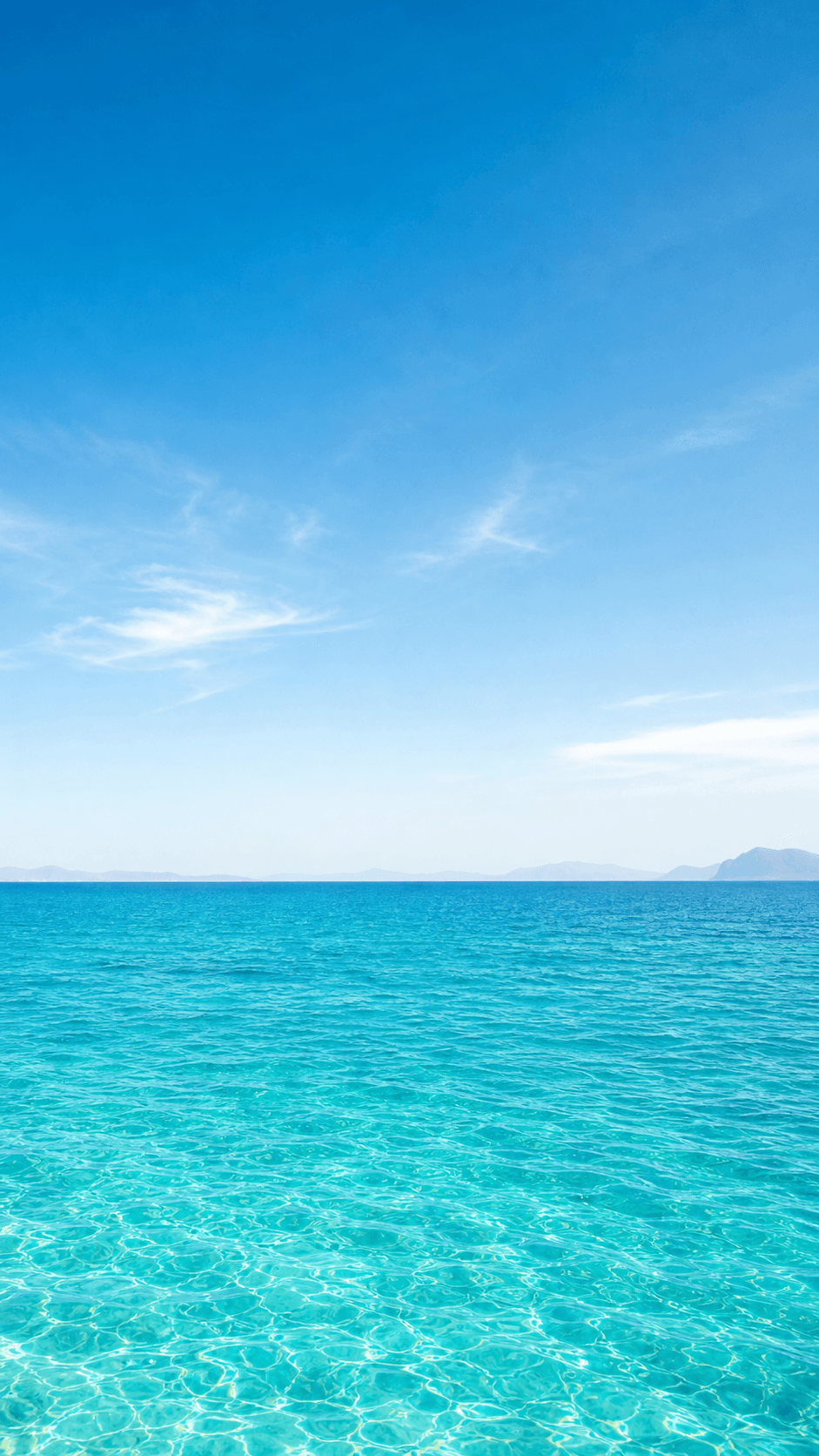 A bright blue sea beneath a summer sky
